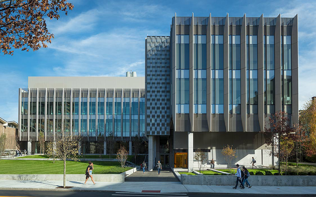 Large modern building with people walking in front.