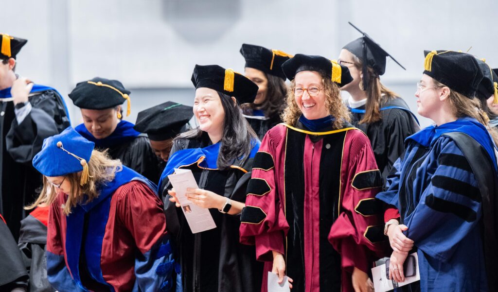 A group of men and women in academic robes at convocation.